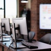 Nobody in office with multiple monitors at customer service desk, call center helpline support to give telecommunication assistance. Empty helpdesk with client telephony reception.